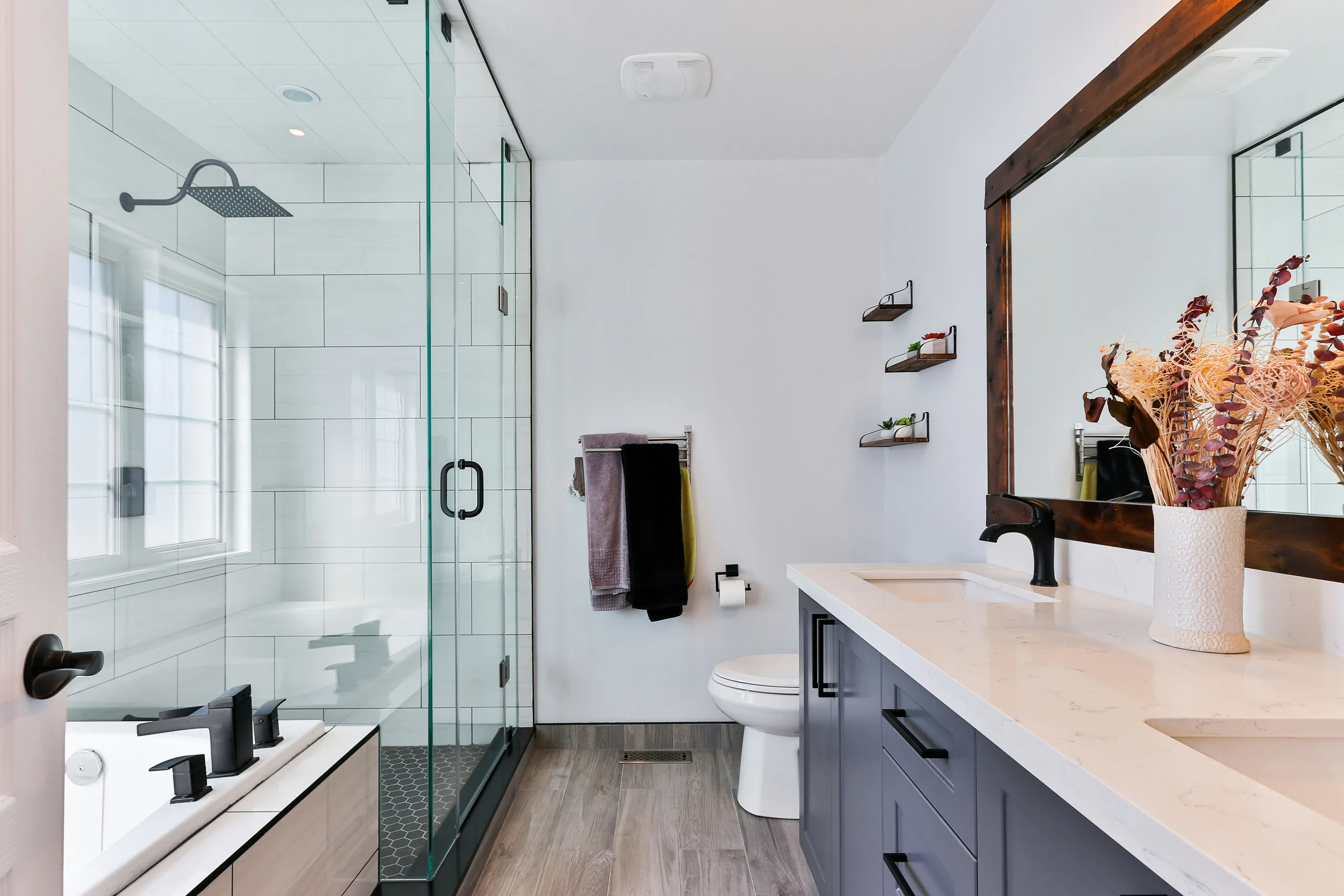 Baño con madera, ducha y lavabo iluminado — proyecto de Studio Design